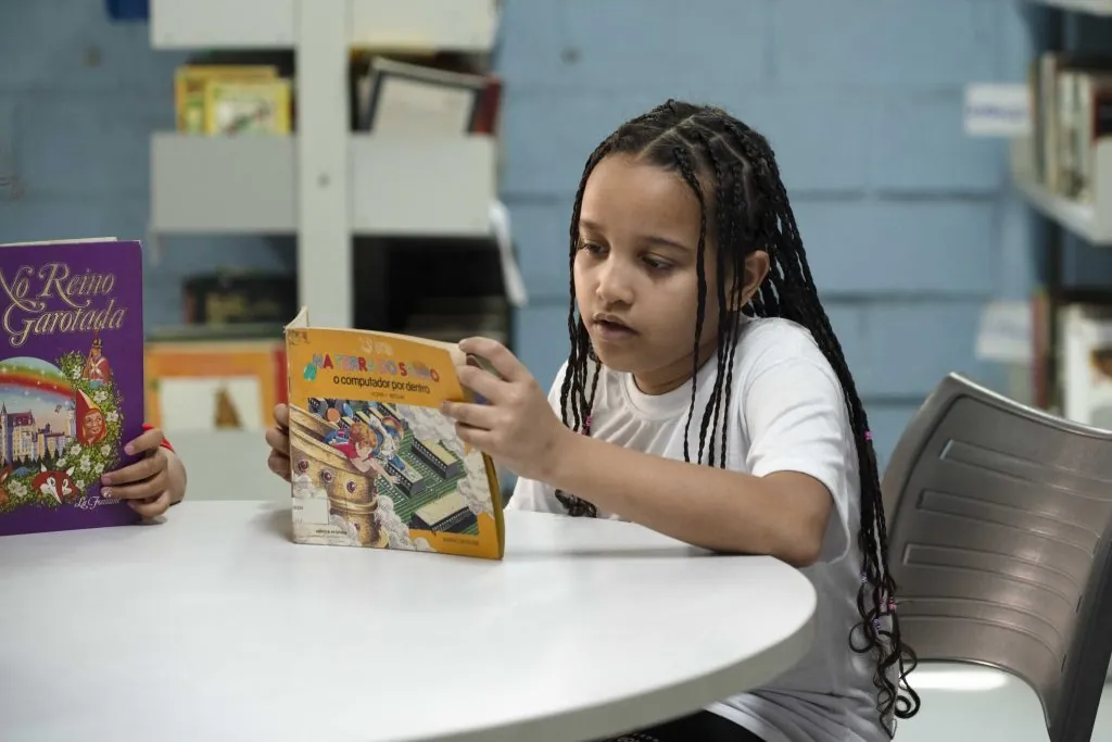 Criança em atividade de leitura na biblioteca